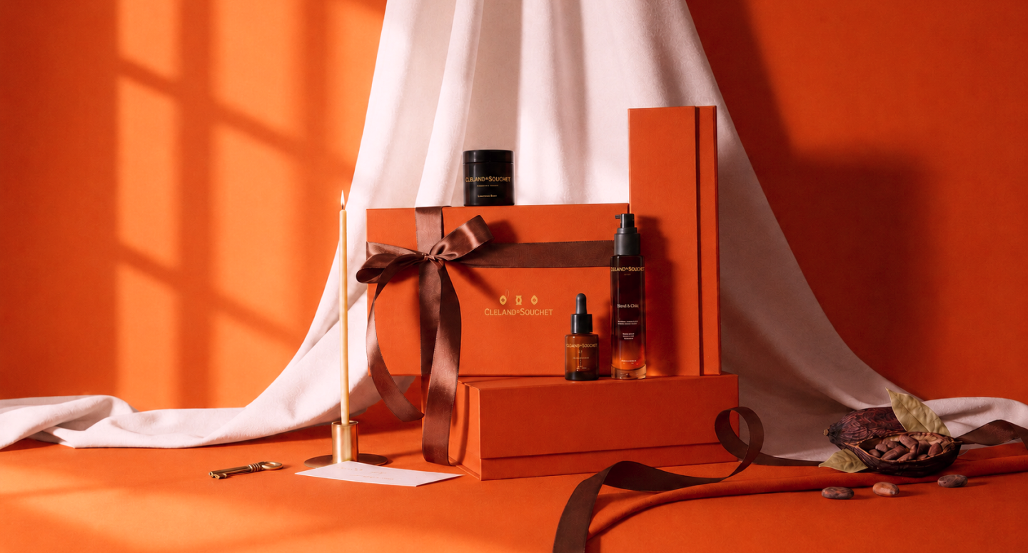 Fragrances and candles arranged on an orange backdrop